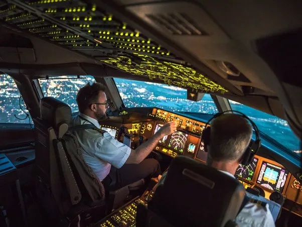 Two pilots in the cockpit of an airplane at night